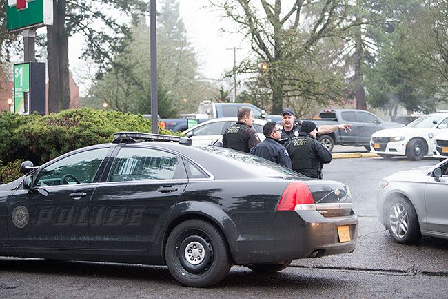 Marcus Larson/News-Register##
After apprehending the suspect near 7-Eleven, McMinnville police officers and Yamhill County Sheriff deputies discuss searching the area and controlling the scene.