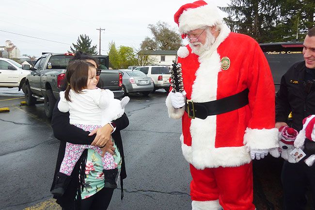 Starla Pointer / News-Register##
Santa and Carlton Police Officer Tim Jordan visit with little Raylin during the special holiday patrol Saturday.