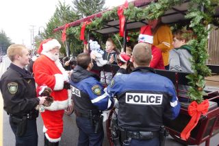 Starla Pointer/News-Register##Carlton police officers and Santa stop a horse-drawn carriage Saturday in order to give youngsters stuffed animals and candy. The “Santa Patrol” is a Christmas tradition in Carlton, although this is the first time police have stopped a horse-drawn vehicle during the event. Starla Pointer/News-Register##Carlton police officers and Santa stop a horse-drawn carriage Saturday in order to give youngsters stuffed animals and candy. The “Santa Patrol” is a Christmas tradition in Carlton, although this is the first time police have stopped a horse-drawn vehicle during the event.