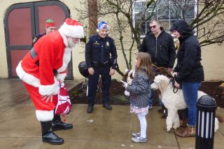 Starla Pointer / News-Register##
Abigail Wheeler, 6, tells Santa about herself when they meet on Monroe Street in Carlton. Police Chief Kevin Martinez, center, reminded kids that Santa wants them to do nice things for others.