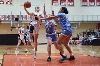 Rusty Rae/News-Register##Sophomore guard Macie Arzner drives the lane for a score in the third quarter against Lakeridge’s Caiden Levrets and Zoey Davis.