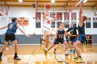Rusty Rae/News-Register##Willamina’s Cohen Haller shoots over Amity’s Trent Carton during Amity’s 48-42 victory over Willamina on Dec. 6. It was Amity coach Devin McShane’s first win as the Warriors coach.