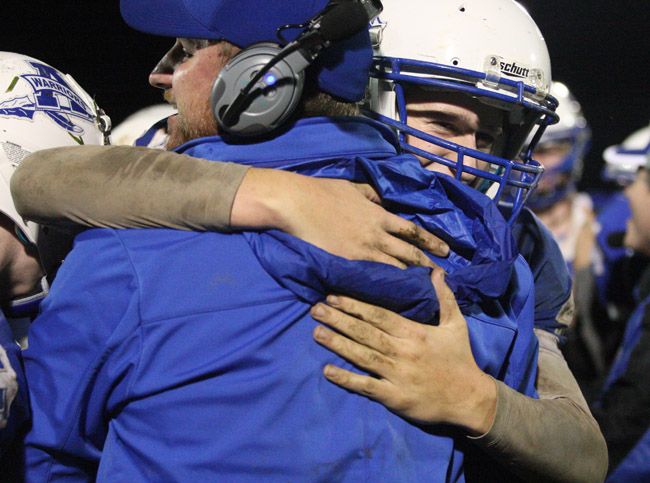 Rockne Roll/News-Register##
Amity s Jamie Stull hugs an assistant coach after the Warriors  win over Dayton Friday night.