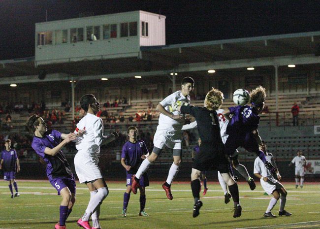 Rockne Roll/News-Register##
Cameron Autencio (center, in white) watches his header sail towards the back of the net in the third minute of Tuesday s playoff match.