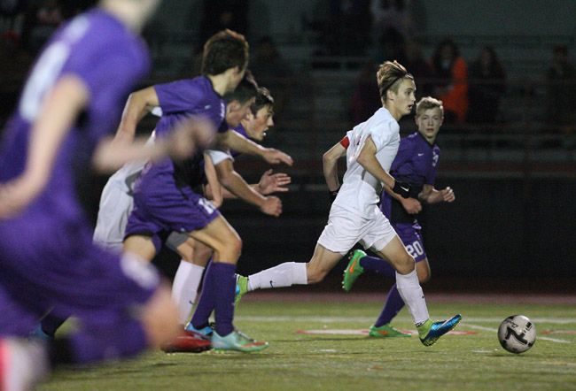 Rockne Roll/News-Register##
Jonah Crown (in white) cuts through the Axemen s defense in Tuesday s OSAA Class 6A Round of 16 match at Wortman Stadium.