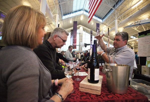 Rockne Roll/News-Register##
Dyson Demara of Hillcrest Winery, right, discusses his wine with Gary and Deb Tipton of Eugene on Friday, March 11, at the Sip McMinnville Wine and Food Classic at Evergreen Space Museum.