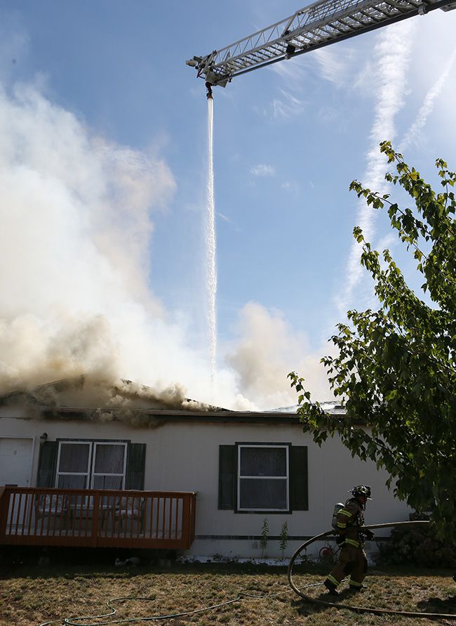 Rockne Roll/News-Register ##
A ladder-mounted sprayer from Tualatin Valley Fire and Rescue sprays down the burning home at 1820 SW Alexandria St. in McMinnville on Friday afternoon.