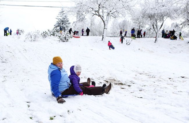 Rockne Roll/News-Register##Cori Hakola and 8-year-old Peyton Hakola hit the bottom of a hill near Northwest Second Street at Lower City Park in McMinnville on Wednesday.
