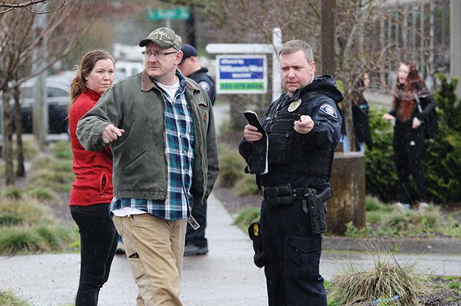 Rockne Roll/News-Register##
A McMinnville police officer interviews a witness following a pedestrian-vs.-vehicle collision at the corner of 12th and Adams Streets in McMinnville on Tuesday, March 14.