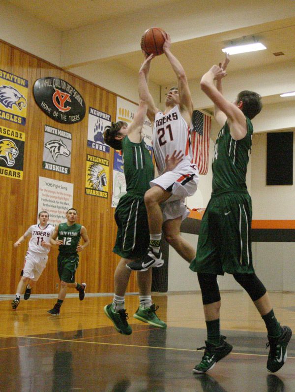Rockne Roll/News-Register##
Y-C guard Luca Queirolo, in white, takes a pair of North Marion defenders to the basket in the Tigers  Class 4A Oregon West Conference home game against the Huskies at Barnett Court in Yamhill on Friday, Feb. 5.