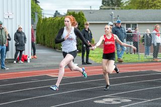 Rusty Rae/News-Register##Anna Schaffner hands the baton to Brooklyn Summers during the 4x100-meter relay. Schaffner, Summers, Delaney Snaric and Marley Darling Peterson won the event with a time of 51.56 seconds.