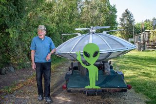 Rusty Rae/News-Register##Kenneth Laufman laughs as he talks about how a flying saucer ended up in his driveway in Dayton. He and his little green friend will be featured Saturday in McMinnville’s UFO parade, which starts at 3:30 p.m. downtown.