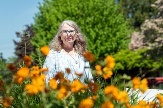 Rusty Rae/News-Register##Linda Mihnes enjoys her front yard, which features bright flowers with something always in bloom.
