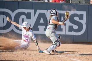 Rusty Rae/News-Register##Katie Phillips slides in safely to score the winning run in the first game of the NCAA McMinnville Regional, which the ‘Cats won 7-6.