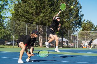 Brandon Bomberger/News-Register##Jameson Rickards leaps and sends a ball back toward his opponents. Rickards and Tommy Gabrielsen (left) earned the number eight seed in the state tournament and won a match in Beaverton before falling in the second round.