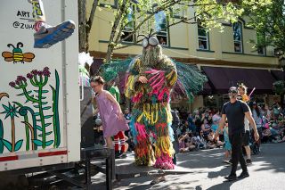 Rachel Thompson/News-Register##Celebrating the life-giving properties of earth-bound insects is Todd Severson of McMinnville as “bearded peacock-feather space fly guy” on the Chapul Farms float.