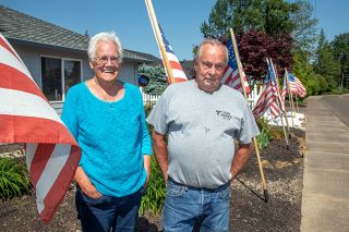 Rusty Rae/News-Register##Sharon and Owen Johnson stand among their flags, including examples from different periods in American history. They display them every day on Wallace Road in McMinnville.