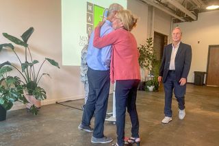 Starla Pointer/News-Register##Steve Fitzpatrick hugs Ellen Summerfield, director of the Give a Little Foundation, as he presents the nonprofit with a check during the McMinnville Area Community Foundation event May 25. Summerfield’s husband, Phillip Pirages, is on the right.