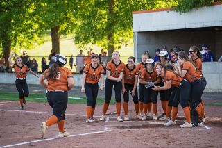Rachel Thompson/News-Register##Cecelia Petraitis is welcomed home by her teammates after blasting a game-tying two-run home run against Burns. Petraitis was down 1-2 in the count, but dropped the head of the bat on an offspeed pitch and lifted it over the left field wall.
