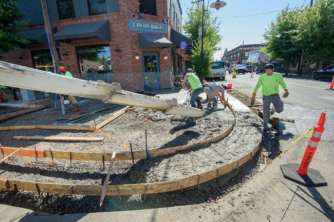 Rusty Rae/News-Register##A crew pours concrete into forms that will create a rounded corner with ramps for accessibility to wheelchairs and people with disabilities at Kutch and Main streets in Carlton. The Oregon Department of Transportation is upgrading sidewalks along Highway 47 in the downtown area this month to improve safety, as well as access.