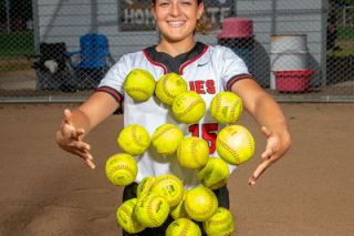 Rusty Rae/News-Register##Abby Carsley with 20 softballs, one representing each of her 20 home runs in her record breaking season. While she will work out with previous record holder Brynn McManus this summer, she said she won’t talk smack about the record, noting she has a lot of respect for her and her game.