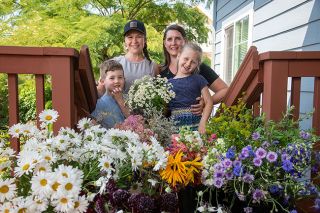 Rusty Rae/News-Register##Sara and Emily Linnertz with their children, Hayes, 4, and Harlowe, 6, show off flowers they grow for their business, Front Porch Flowers. They use locally grown blooms whenever possible, Emily Linnertz said.