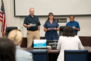 Rachel Thompson/News-Register##McMinnville School Superintendent Debbie Brockett, facing away, leads the swearing in of one new school board member and two incumbents — from left, Larry Vollmer, newly elected Doris Towery, and Gerardo Partida. Elected in May, they were sworn in July 10 at the first meeting of the fiscal year.