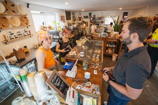 Rachel Thompson/News-Register##Employees Eddie McKenzie, left, and Kym Brand help customer Will Earthman at Alchemist’s Jam in McMinnville. The retail shop at 207 N.E. Ford St. focuses on selling jams, breads and pastries, along with other items made by local producers.