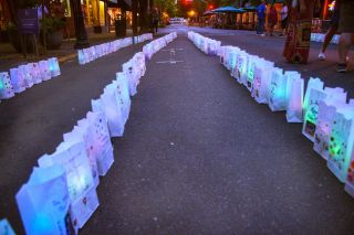 Rusty Rae/News-Register##About 300 decorated luminaria line Third Street between Davis and Evans Friday in the Relay for Life “Light the Night With Hope” event. Each luminaria carried a name, and many bore messages such as “A loving wife,” “You will be missed” and “To all who have suffered.” A short ceremony and memorial walk capped the evening, These luminaria and others will be honored at the Relay For Life main event Sept. 23 in Dayton.