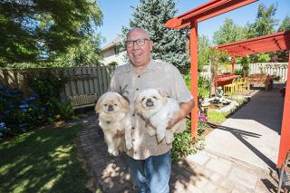 Rachel Thompson/News-Register##Beloved dogs Leo and Sammy join Kevin Peterson in the yard he and wife Helen have been tending since coming to McMinnville eight years ago. They brought many sculptures with them when they moved to Oregon from Minnesota.