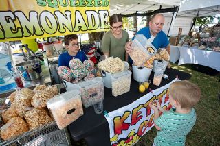 Rachel Thompson/News-Register##Salty Kettle’s Malachai, Aleiah, and Trever Barnes serve a sample of kettle corn to Caleb Bute of McMinnville on Saturday during Old-Timers Weekend at Dayton’s Courthouse Square Park. After sampling several flavors, Caleb decided on caramel.