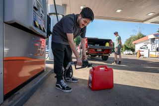 Rachel Thompson/News-Register##Cashier Gabriel Ruiz fills a five-gallon gas can with unleaded for customer John Vineyard of McMinnville at the 76 station on Southwest Baker Street. Ruiz demonstrates the proper practice of keeping the vessel on the ground while filling.