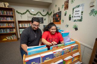 Rachel Thompson/News-Register##With help from her younger brother, David, Monse Martinez-Ponce files books for her fourth-graders at Memorial Elementary to read. Her first experience with teaching was when she was a Mac High student helping in her brother’s fifth-grade classroom.