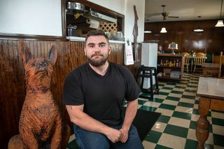 Rusty Rae/News-Register##Austin Zirkel of McMinnville is the new owner of Coyote Joe’s Restaurant in Willamina. He bought the business from longtime owner Rolly Heuser, who retired. A wood carving of a coyote sits near the kitchen.