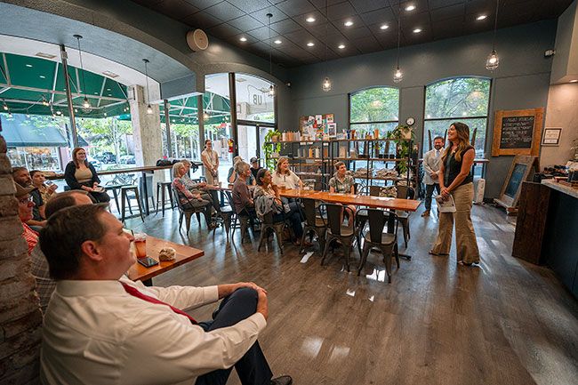 Rachel Thompson/News-Register##McMinnville’s Andrew Anderson, left foreground, listens as Rep. Lucetta Elmer, right, speaks in her town hall Aug. 23 at Union Block Coffee. The audience was small but the discussion was lively.
