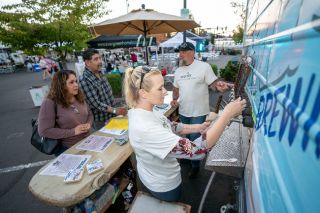 Rachel Thompson/News-Register##Christina Wing pours a taste of beer for Maria and Gabriel Barrios of Amity during the McMinnville Area Chamber of Commerce&rsquo;s new festival over the weekend. Wing and Jason Smith, right rear, were among numerous people who volunteered to help run Brews, Bites & Bands.