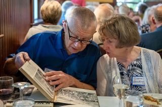 Rusty Rae/News-Register##Terry Armstrong and wife, Diane, look through a 1963 McMinnville High School yearbook, filled with memories of Armstrong’s graduating class.
