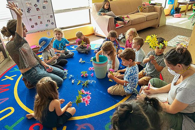 Dawn Elliott photo##McMinnville Playschool teacher Teressa DiAndrea solicits ideas from students about how to care for the school garden. DiAndrea is the program’s sole employee; parents take turns volunteering in the classroom.