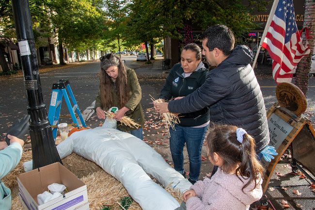 Rusty Rae/News-Register##
From left, Lisa Springer, Sara Herrera, Javier Ceja and Mariel Ceja stuff the J&S Restorations entry for the McMinnville Downtown Association’s Scarecrows on a Lamp Post” contest. Their scarecrow and 14 others will be on display along Third Street through Halloween.