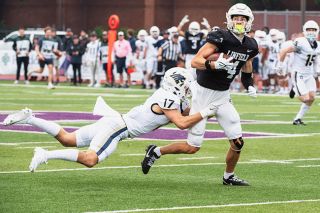 Rusty Rae/News-Register##Linfield graduate student and wide receiver Devon Murray had five catches against Puget Sound for 100 yards and two touchdowns. In this file photo, he runs through the tackle of George Fox safety Austin Canchola.