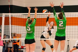 Tanner Russ/News-Register##Yamhill Carlton volleyball’s lone senior Adelle Petraitis (9) sends a ball past Rainier middle blocker Lilli Dean (2). Yamhill Carlton won 3-0 (28-26, 25-22, 25-22) in the league playoff game at the Tiger Dome.