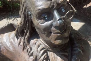 Kirby Neumann-Rea/News-Register##Ben Franklin’s eyeglasses have been repaired since this mid-fall, but white paint for eyes is newer vandalism arts committee chair Steve Rupp plans to repair. The popular bench sculpture is at Northeast Third and Davis streets.
