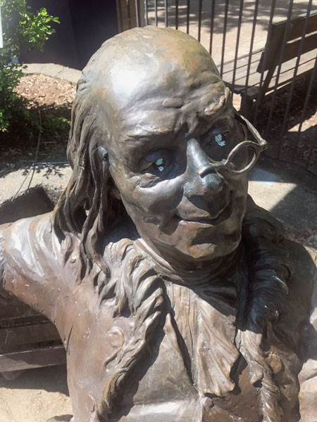 Kirby Neumann-Rea/News-Register##Ben Franklin’s eyeglasses have been repaired since this mid-fall, but white paint for eyes is newer vandalism arts committee chair Steve Rupp plans to repair. The popular bench sculpture is at Northeast Third and Davis streets.