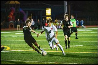Rusty Rae/News-Register##McMinnville sophomore Abraham Cuevas-George drives to the goal against Newberg defender Caden Johns in the final regular season game.