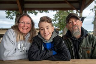 Rusty Rae/News-Register##Nick and Jenni Amerson, with their son Garrett, are happy to no longer have to keep Garrett’s shoe design secret. Chosen as one of six youngsters to design Nike shoes for a Doernbecher fundraiser, they had to stay mum until the auction on Friday.