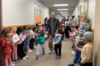 Starla Pointer/News-Register##As students wave flags and call out “thank you,” veteran Michael McClure walks the halls of Grandhaven Elementary School with his grandchildren, Brooks McBride, a second-grader, and Jensen McBride, a kindergartner.