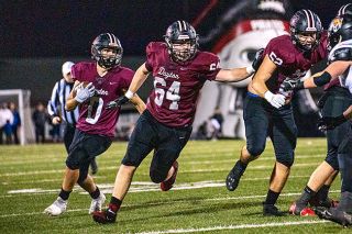 Rachel Thompson/News-Register##Dayton’s Cannon Capener (64) was a first team all-league offensive lineman, and leads senior running back Alex Garcia (0) who was a second team all-league running back.