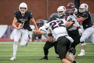 Rusty Rae/News-Register##Linfield freshman and backup quarterback Luke McNabb scrambles to evade the Whitworth defense. McNabb passed for all three of the Wildcats’ touchdowns in the final game of the season.