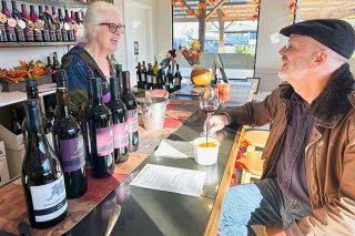 Kirby Neumann-Rea/News-Register##Carol Fredrick, co-owner of Stone Griffon Vineyards in Carlton, talks Tempranillo with Tim O’Connor of Portland, who also enjoys a bowl of Fredrick’s squash soup, on the day after Thanksgiving.