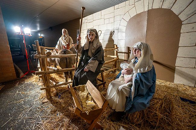 Rachel Thompson/News-Register##A shepherd (Caybrie Bradley), left, joins Joseph (Joseph Marks) and Mary (Natalie Bradley, holding a doll for the Christ child) in the live nativity scene at Baker Creek Community Church on McMinnville’s Baker Creek Road. Members of the congregation took part in the program Friday and Saturday night, including choir members who sang as visitors passed by the manger scene.